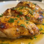 Close-up view of juicy baked honey mustard chicken garnished with parsley.
