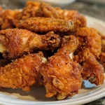 Close-up view of crispy fried chicken wings on a plate.
