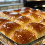 Close-up side view of freshly baked dinner rolls, golden and fluffy.