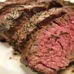 Close-up view of medium-rare roast beef with a juicy, pink center.