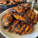 Juicy caramelized BBQ chicken thighs with a shiny glaze.