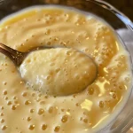 Close-up of creamy vanilla pudding in a glass bowl.