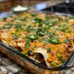 Close-up view of a Chicken Enchilada Casserole garnished with cilantro and jalapeños.