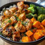 Close-up view of a Maple Dijon Chicken Sweet Potato Bowl with broccoli.
