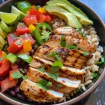 Close-up view of a grilled chicken burrito bowl with colorful ingredients.