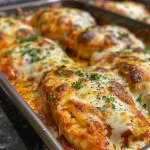 Close-up of a cheesy mozzarella chicken bake with melted cheese and marinara sauce.