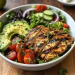 Close-up of a vibrant Grilled Chicken Avocado Salad Bowl with colorful vegetables.