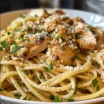 Close-up of a bowl of Healthy Garlic Butter Chicken Pasta with chicken pieces and spaghetti.