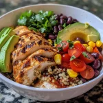 A close-up view of a colorful chicken quinoa power bowl with vibrant ingredients.