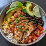 Close-up of a Mexican Chicken and Rice Bowl garnished with avocado slices and cilantro.