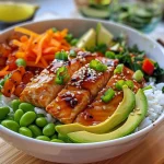 A close-up side view of a Soy Ginger Salmon Bowl featuring vibrant ingredients on a white plate.