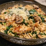 Close-up of a bowl of Spinach Mushroom Orzo with Chicken, showcasing vibrant greens and golden pasta.