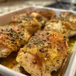 Close-up of juicy baked Italian chicken thighs, garnished and served.
