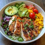 Close-up view of a colorful Chicken Burrito Bowl with rice, chicken, and fresh toppings.