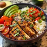 A close-up view of a colorful Chili Lime Chicken Bowl with chicken, bell peppers, and avocado.