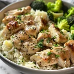 A close-up side view of a creamy garlic chicken rice bowl topped with parsley.