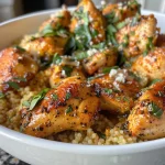 Close-up of juicy garlic butter chicken bites with lemon parmesan couscous.