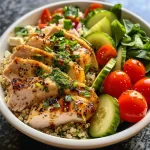 Close-up view of a colorful Garlic Herb Chicken Quinoa Bowl featuring fresh ingredients.
