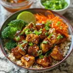 Close-up view of a bowl filled with Healthy Sticky Chicken, rice, and colorful vegetables.