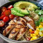 A close-up view of a colorful High-Protein Chicken Quinoa Power Bowl filled with various fresh ingredients.