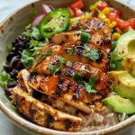 A close-up side view of a colorful Honey BBQ Grilled Chicken Dinner Bowl with fresh ingredients.
