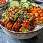 Close-up view of Korean BBQ Chicken Bowls featuring marinated chicken, vibrant vegetables, and rice.