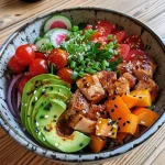 A healthy low carb bowl featuring chicken, cauliflower rice, and assorted colorful vegetables.