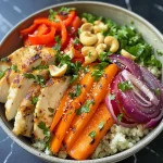 Close-up view of a Millet Bowl featuring grilled chicken and a variety of roasted vegetables.