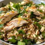 Juicy roasted chicken atop a bed of barley salad with fresh vegetables.