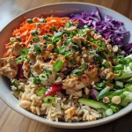Close-up view of Spicy Thai Chicken and Brown Rice Bowl, showcasing vibrant vegetables and ground chicken.