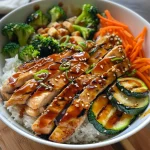 Close-up view of Teriyaki Grilled Chicken and Veggie Rice Bowl with colorful vegetables.