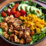 Close-up view of a colorful Tropical Chicken Salad with mango dressing, featuring vibrant vegetables and succulent chicken pieces.