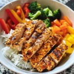 Close-up view of a colorful Chicken and Veggie Power Bowl with bright vegetables and rice.
