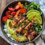 ['A close-up view of a bowl filled with colorful Chili Lime Chicken and vibrant vegetables.', 'Side shot of a Chili Lime Chicken Bowl showcasing juicy chicken, sliced peppers, and avocado.', 'A beautifully arranged Chili Lime Chicken Bowl with cilantro lime rice, cherry tomatoes, and fresh herbs.', 'Tantalizing close-up of a chicken bowl featuring lime-infused chicken, avocado slices, and bright bell peppers.']