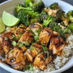 ['Close-up view of grilled chicken and broccoli served in a bowl.', 'Juicy grilled chicken pieces with bright green broccoli in a bowl.', 'Delicious grilled chicken and steamed broccoli with creamy sauce.', 'Colorful grilled chicken and broccoli bowl with lime wedges.']