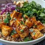 ['Juicy Honey Sriracha chicken served over quinoa, garnished with scallions and cilantro.', 'A vibrant bowl of Honey Sriracha Chicken Quinoa with colorful toppings.', 'Close-up of a quinoa bowl featuring chicken, honey sriracha sauce, and fresh garnishes.', 'A delicious Honey Sriracha Chicken Quinoa Bowl with a side view showcasing its ingredients.']