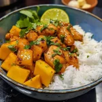 ['Close-up view of a plate featuring juicy Mango Chicken with vibrant mango slices.', 'Side view of Mango Chicken dish with golden-brown chicken and fresh mango garnish.', 'Appetizing Mango Chicken with a glossy glaze, served in a rustic dish.', 'Juicy Mango Chicken surrounded by colorful ingredients like mango and herbs.']