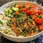['Close-up view of a Mediterranean chicken bowl featuring juicy chicken, rice, diced cucumber, and tomatoes with a lemon garlic sauce.', 'Side angle of a Mediterranean chicken bowl showcasing cooked rice, fresh tomatoes, diced cucumber, and succulent chicken pieces.', 'Colorful Mediterranean chicken bowl with vibrant ingredients including chicken, cucumber, and tomatoes, drizzled with lemon garlic sauce.', 'Appetizing close-up of a chicken bowl filled with rice, diced cucumber, fresh tomatoes, and flavorful lemon garlic sauce.']