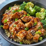 ['Close-up of a Teriyaki Chicken Quinoa Bowl with broccoli and garnishes.', 'Side view of a vibrant Teriyaki Chicken Quinoa Bowl featuring succulent chicken and fresh broccoli.', 'Detailed view of a healthy Teriyaki Chicken Quinoa Bowl filled with ingredients and garnished with sesame seeds.', 'Colorful display of Teriyaki Chicken with quinoa and broccoli in an appealing bowl.']