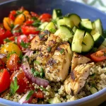 ['Close-up view of a Mediterranean chicken quinoa bowl filled with colorful vegetables.', 'A vibrant quinoa bowl featuring diced chicken, red bell pepper, zucchini, and cherry tomatoes.', 'A healthy meal prep bowl showcasing chicken, quinoa, and fresh Mediterranean ingredients.', 'Side view of a delicious quinoa bowl with colorful ingredients and a creamy tahini dressing.']