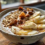 ['A close-up view of a vibrant apple smoothie bowl topped with granola and fresh fruits.', 'Side angle of a creamy apple smoothie bowl filled with chopped apples and nuts.', 'An intricate bowl of apple smoothie, featuring colorful toppings like banana slices and almond butter.', 'A detailed look at an apple smoothie bowl, showcasing its rich texture and various toppings.']