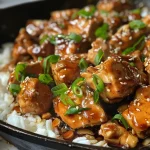 ['A close-up side view of a Bourbon Chicken Skillet with juicy chicken pieces and colorful garnishes.', 'A detailed shot of Bourbon Chicken in a skillet, showcasing tender chicken and garnished with green onions and sesame seeds.', 'A vibrant image of a Bourbon Chicken dish, featuring a mix of glistening chicken pieces and flavorful sauce.', 'A skillet filled with Bourbon Chicken, highlighting the delicious caramelized look of the chicken and toppings.']