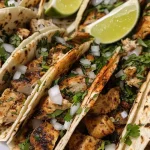 ['Close-up view of Chicken Street Tacos featuring diced chicken on corn tortillas.', 'Juicy Chicken Street Tacos garnished with diced onions and cilantro, served with lime wedges.', 'Side view of flavorful Chicken Street Tacos with fresh ingredients, ready to eat.', 'Delicious Chicken Street Tacos displayed on a plate, highlighting toppings and textures.']