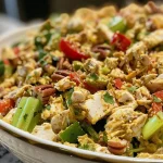['A close-up side view of a vibrant Curried Chicken Salad featuring diced chicken and colorful vegetables.', 'Juicy Curried Chicken Salad displayed in a bowl, showcasing diced chicken, celery, and red pepper.', 'A detailed view of a fresh Curried Chicken Salad with chopped pecans and spices, served in a white dish.', 'Side angle of a delicious Curried Chicken Salad, highlighting the mix of chicken, veggies, and creamy dressing.']