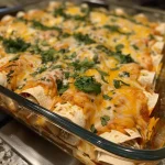 ['A close-up view of juicy turkey enchiladas topped with cheese and fresh cilantro.', 'Side view of delicious turkey enchiladas garnished with lime and green herbs.', 'Close-up photo showcasing turkey enchiladas filled with colorful vegetables and cheese.', 'Juicy turkey enchiladas served in a white dish, drizzled with enchilada sauce and herbs.']