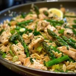 ['Close-up of a vibrant plate of orzo with chicken pieces and asparagus.', 'Side view of a delicious bowl of orzo with cooked chicken and fresh asparagus.', 'Juicy orzo dish featuring diced chicken and bright green asparagus tips.', 'Close-up shot of a colorful orzo meal with chicken, asparagus, and herbs.']