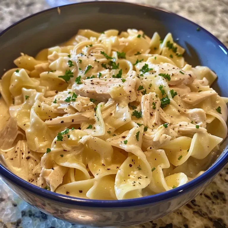 Close-up image of creamy chicken and noodles with shredded rotisserie chicken and egg noodles.