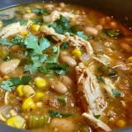 A close-up view of a bowl of Slow Cooker White Chicken Chili, showcasing its creamy texture and visible ingredients.